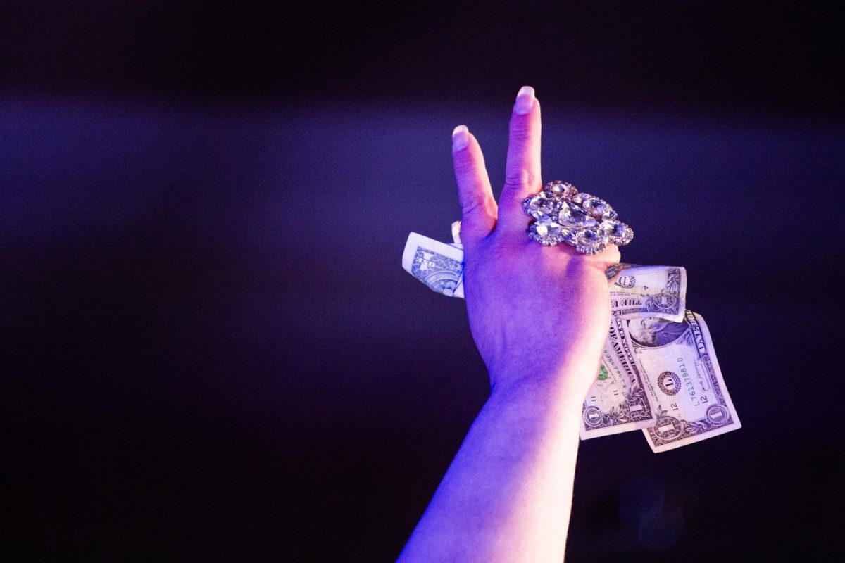 Drag queen Geneva Ladiva holds a wad of cash tips during her lip-sync performance at the 9th Annual WKU Housing and Residence Life Drag Show at Knicely Conference Center on April 4, 2024. 