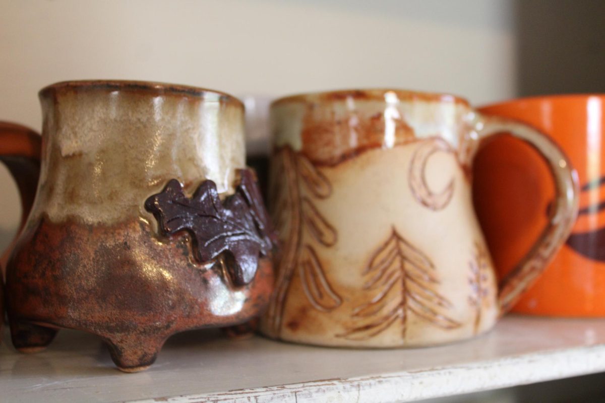 Previous cauldron mugs rest in a cabinet in her studio in her kitchen. Each mug was created by Hope Waters, potter of Big Nose Clay, in Bowling Green.