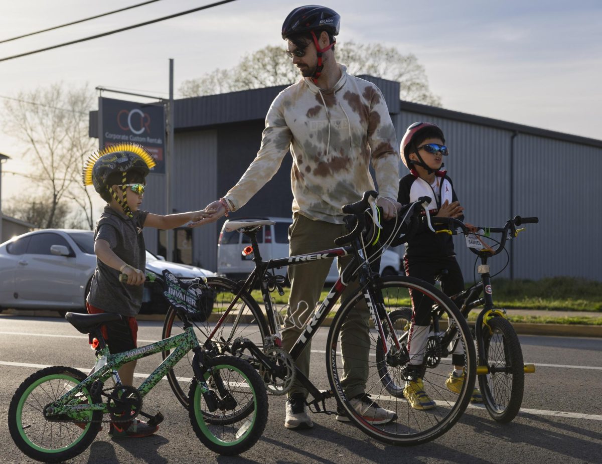 Participant Kyle Marklin congratulates his sons, six-year-old participant Lucas Marklin (left) and nine-year-old participant Samuel Marklin (right) after completing a 10-mile bike ride at BikeWalk BG’s St. Patrick’s “Community Bike Ride” event on March 16.