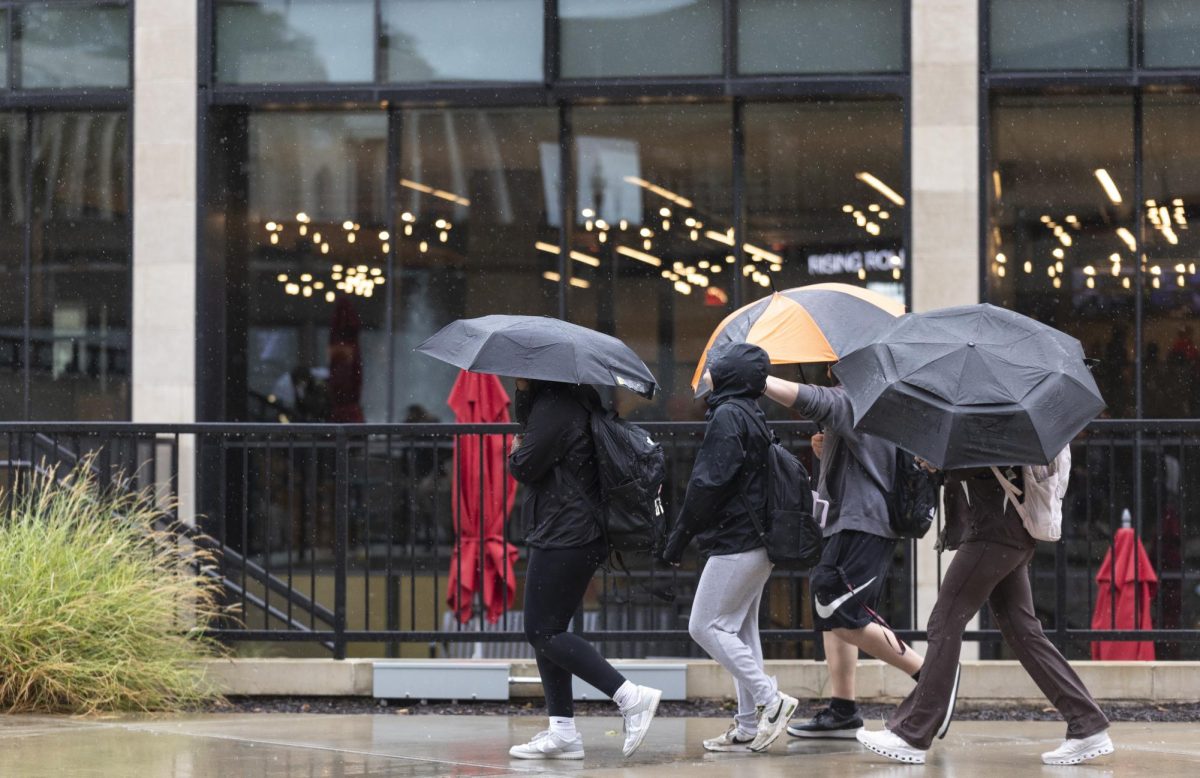 A group of students walk past the Commons in the rain from a weakened hurricane Helene on Friday, Sept. 27, 2024.