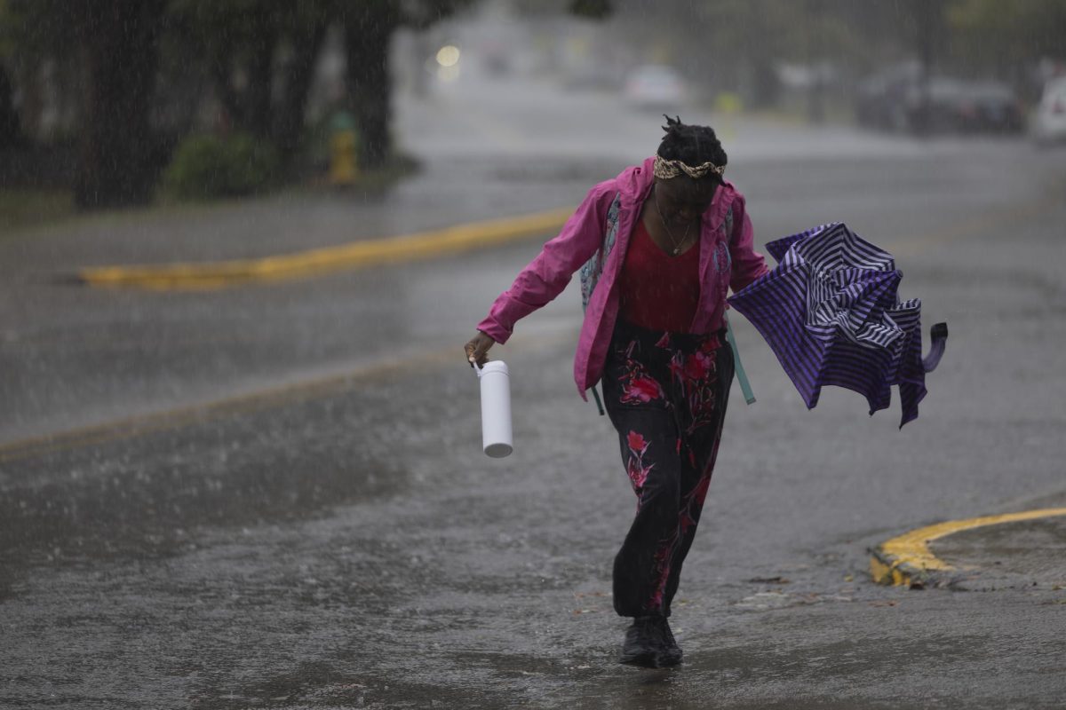 Ancile Igilaneza, freshman, runs to the bus stop cover to stay dry from the rain on campus Friday, Sept. 27, 2024. 