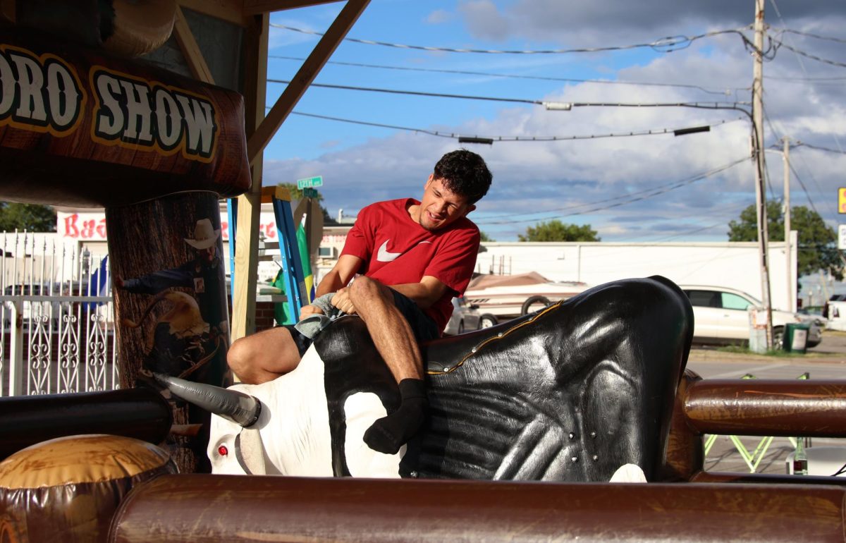 Mefi Luben, 17, rides the “Toro Show” at the BG Fiestval during the mechanical bull competition on Saturday, Sept. 14, 2024.  Mefi won the competition with a time of 29 seconds. 