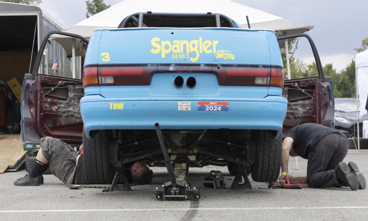 Steve Olson (left) and Russ Cossell (Right) attempt to fix a hole in their cars oil pan during the 24 Hours of Lemons endurance race at the NCM Motorsports Park on Sunday, Sept. 22, 2024.