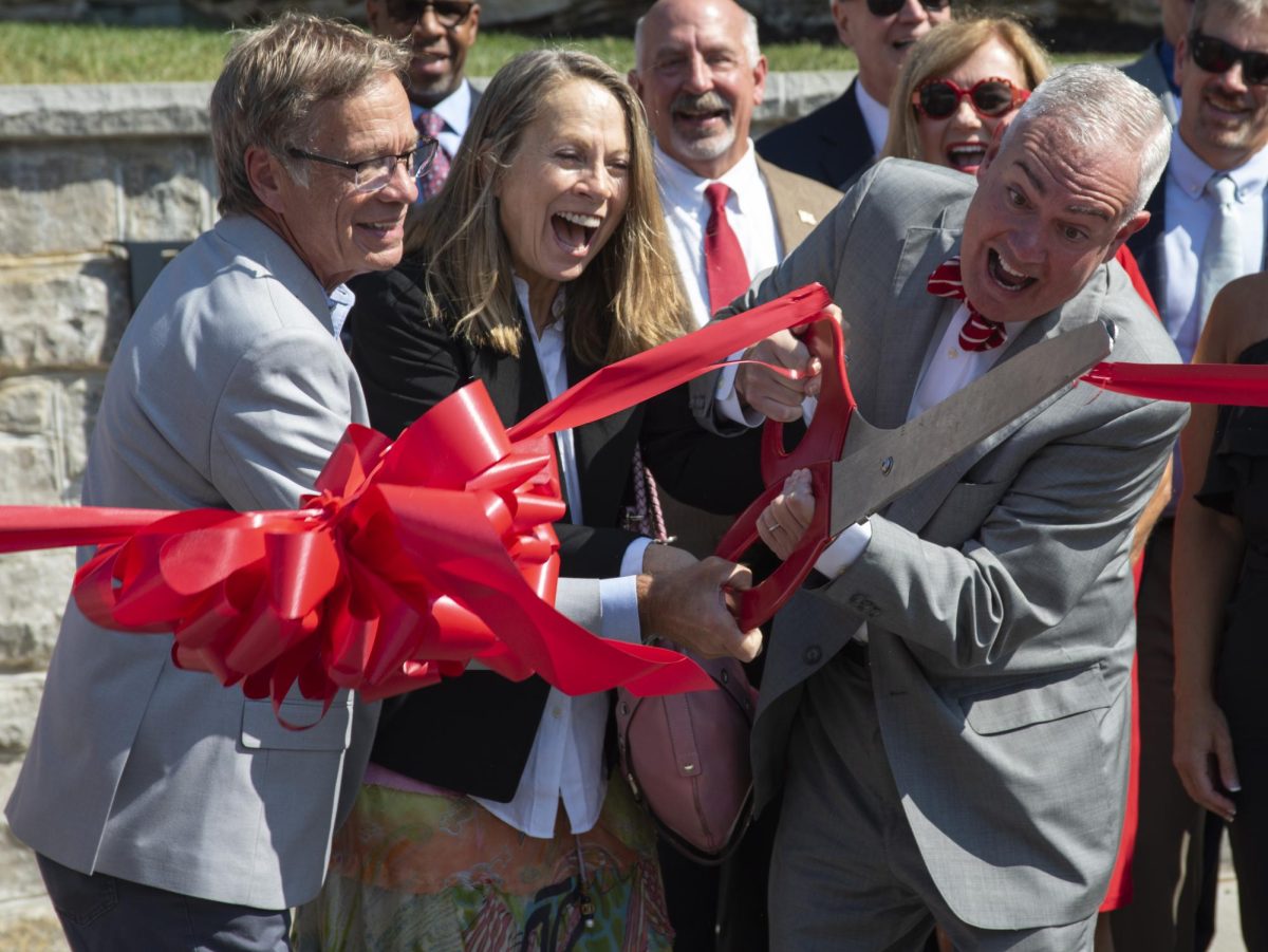 WKU President Timothy C. Caboni, right, Anne Nicolaou, middle, and Pete Garrett cut the ribbon signifying the full dedication of the Garrett Plaza in honor of former WKU President Dr. Paul L. Garrett and his wife Virginia Garrett on Thursday, Sept. 5, 2024. 