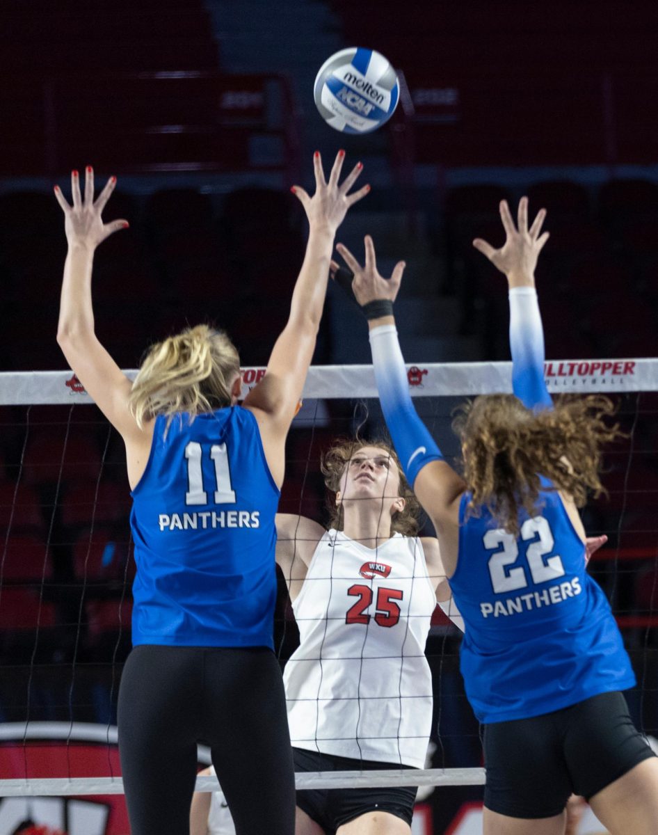 Middle hitter Izzy Van De Wiele (25) attacks the ball towards the Eastern Illinois defense in Diddle Arena on Friday, Sept. 20, 2024.