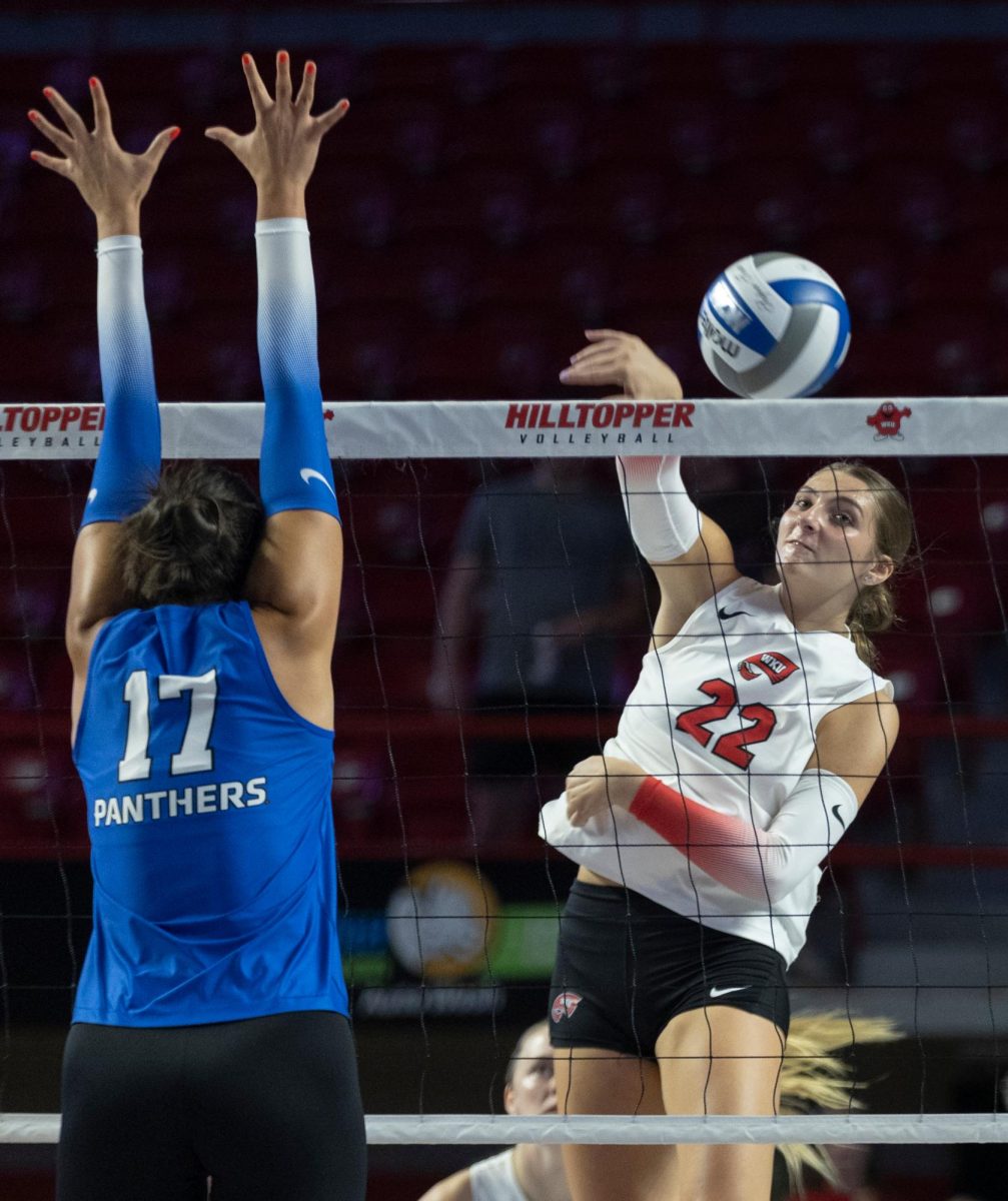 Outside hitter Faith Young (22) spikes the ball past the Eastern Illinois defense in Diddle Arena on Friday, Sept. 20, 2024.