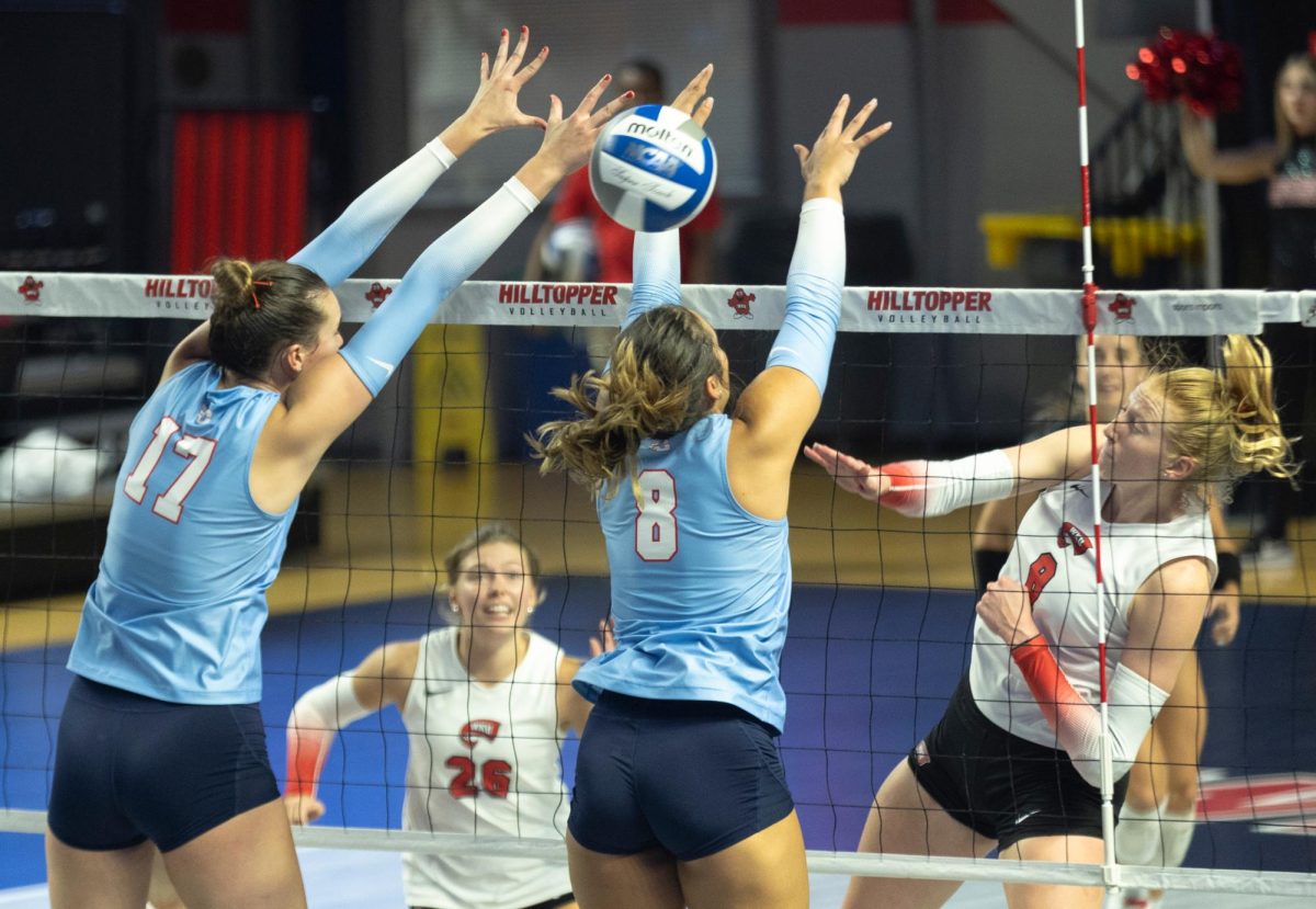 Outside hitter Kaylee Cox (8) successfully hits the ball past University of Dayton defense at Diddle Arena on Friday, Sept. 13, 2024.