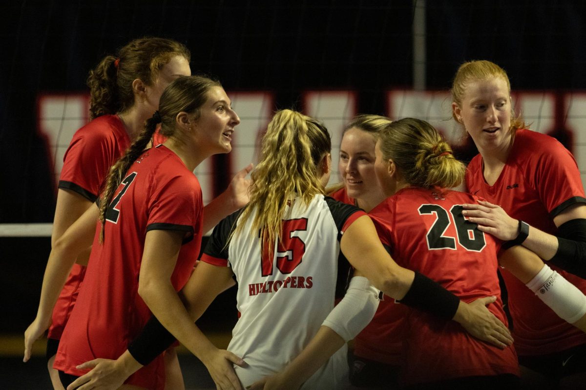 The WKU volleyball team huddles up on the court to celebrate a point made during the game against Arkansas State University at Diddle Arena on Friday, Sept. 20, 2024. 