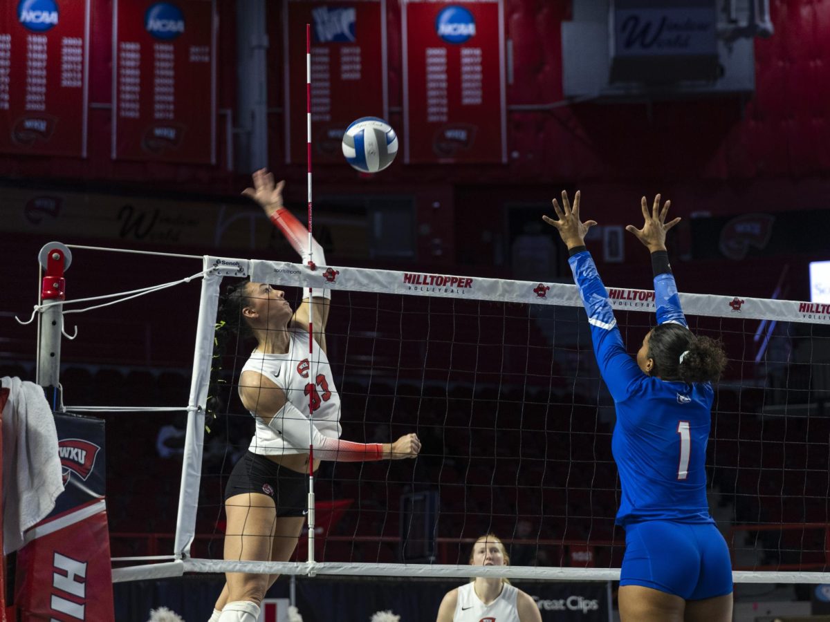 Western Kentucky’s Kenadee Coyle (33) spikes the ball while Louisiana’s Tech’s Izabely Benjamin (1) attempts a block during a game at Diddle Arena on October 18, 2024. 