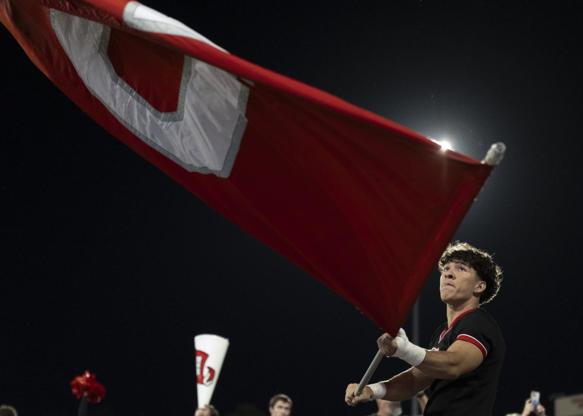 A WKU cheerleader waves a flag before running out in front of the football team in the L.T. Smith Stadium on Wednesday, Oct. 30, 2024.