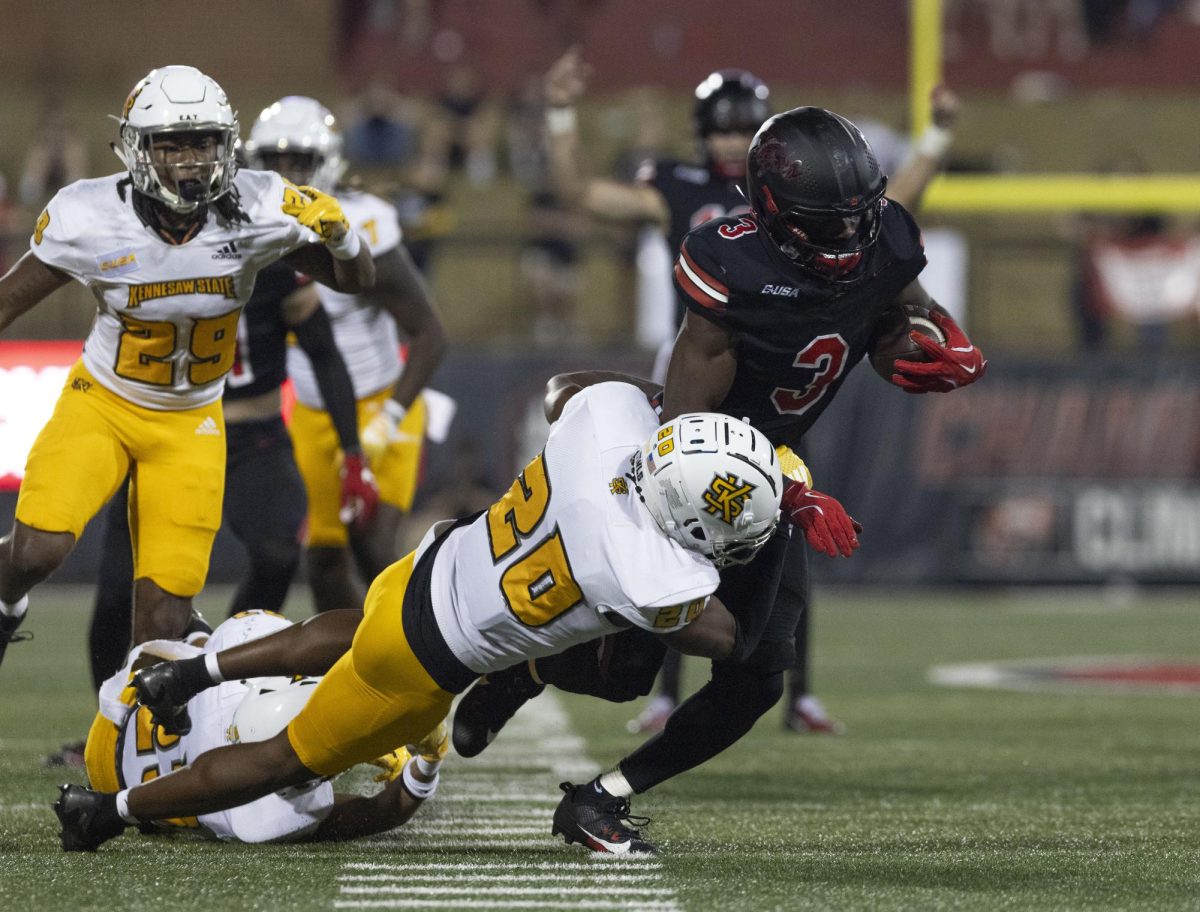 Western Kentucky Hilltoppers running back Elijah Young (3) is pulled down by Kennesaw State Owls defensive back Tyler Hallum (20) in the L.T. Smith Stadium on Wednesday, Oct. 30, 2024.