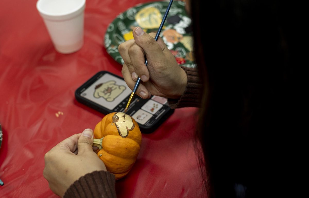 Lily Whorton painting her miniature pumpkin at the WKU Global Event.