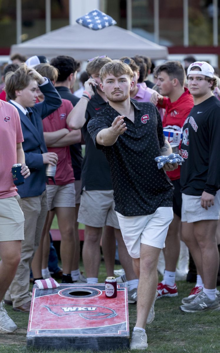 Brady Johnson, a senior finance major and member of Phi Delta Theta fraternity, plays corn hole during the tailgate on south lawn before the Western Kentucky football game against the University Texas at El Paso on Thursday, October 10, 2024. WKU won 44-17