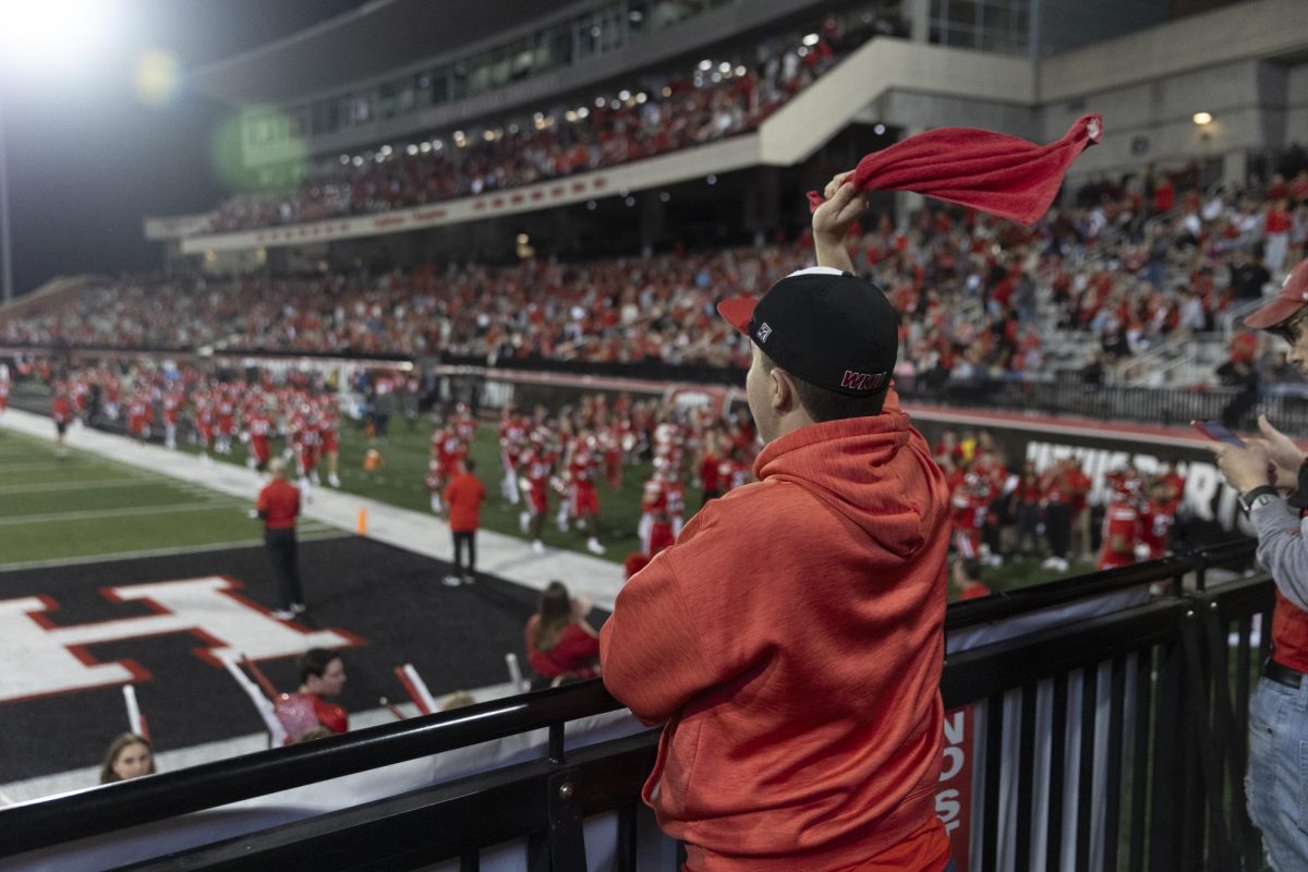 Tyler Tugman, sophomore, waves a red towel in the air to cheer on the football team during WKU’s game against UTEP at Houchens Industries L. T. Smith Stadium on Thursday October 10, 2024. 