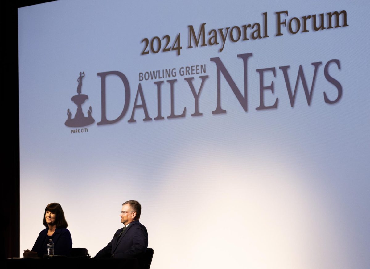 Mayoral candidates Patti Minter (left) and incumbent mayor Todd Alcott are seated by a debate moderator before beginning the Bowling Green Daily News’ Mayoral Forum at Bowling Green Junior High School on Oct. 14, 2024. 