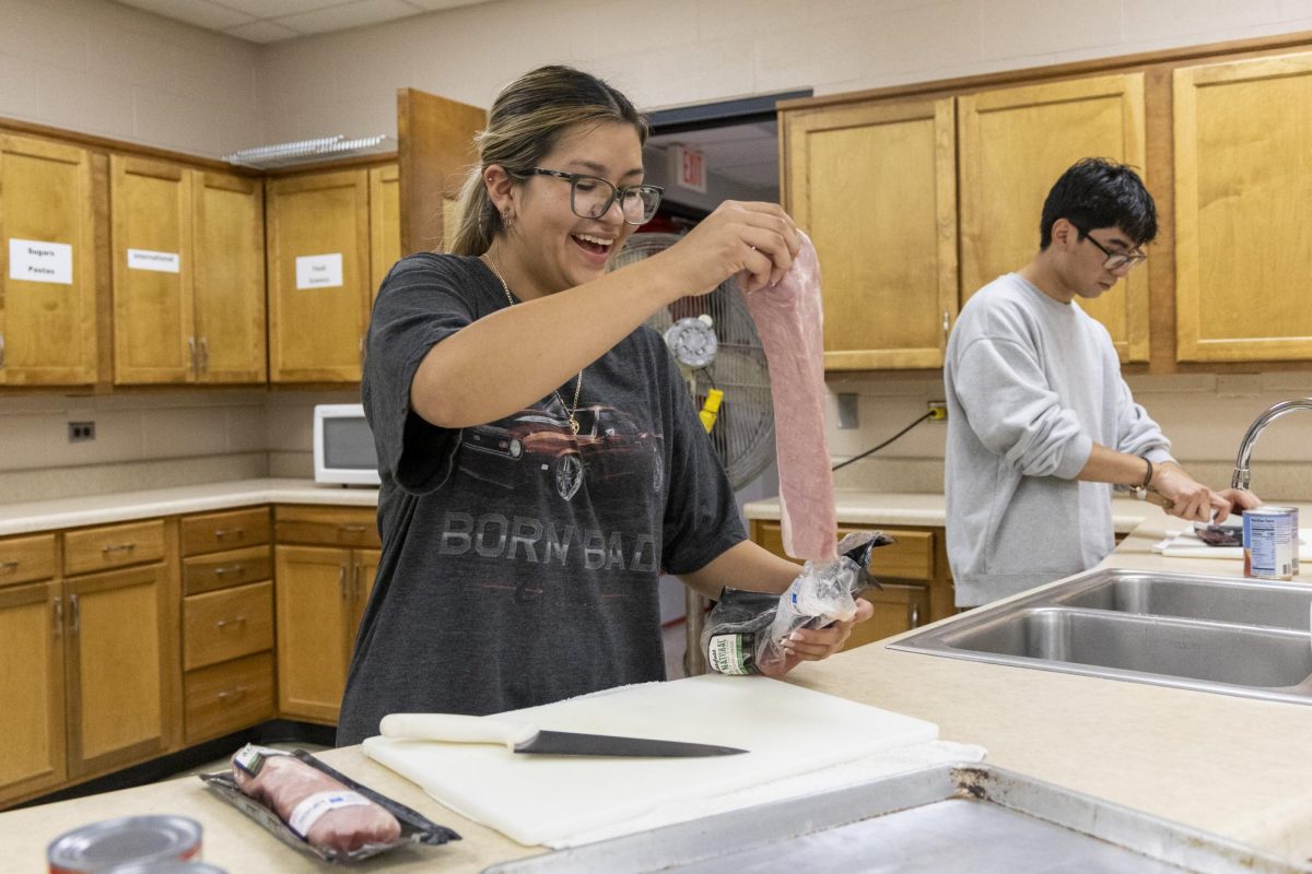 Christina Rocha opens a package of pork during the Topper Chef event hosted by SGA on Monday, Nov. 4, 2024. 