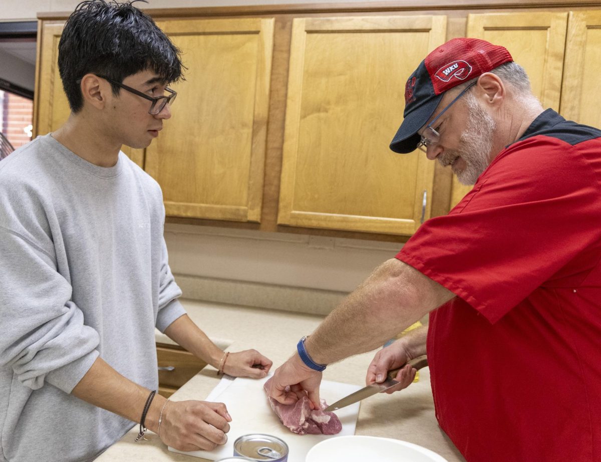 Jose Belez (left) and Dr. Matthew Vanscjenkof work together to cut red meat during the Topper Chef event hosted by SGA on Monday, Nov. 4, 2024. 