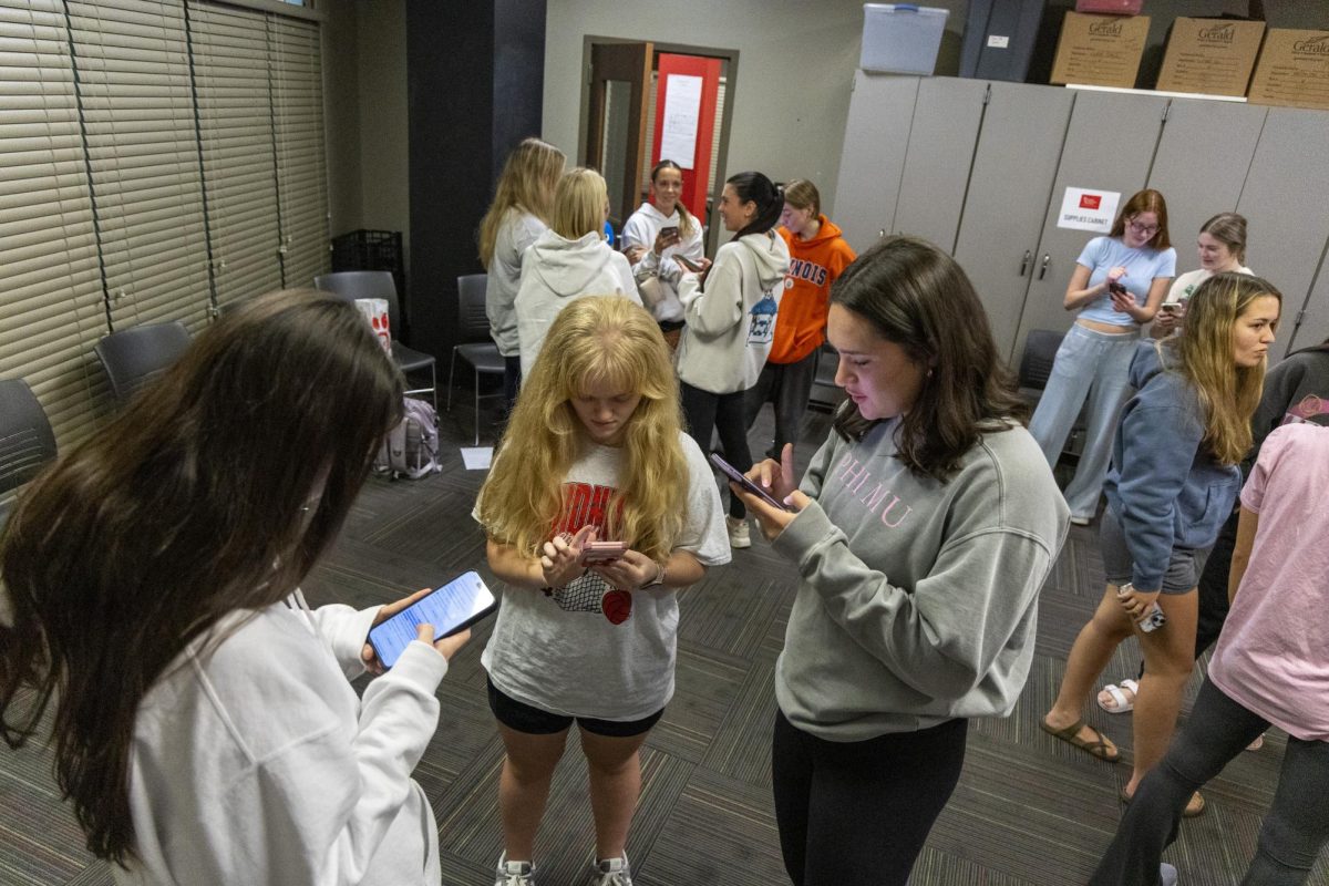 Attendees of the WKU Royal family Fan Club trivia night talk in groups after getting their result on a “Which Royal Family are You” quiz on Buzz Feed on Wednesday, Nov. 6, 2024. 