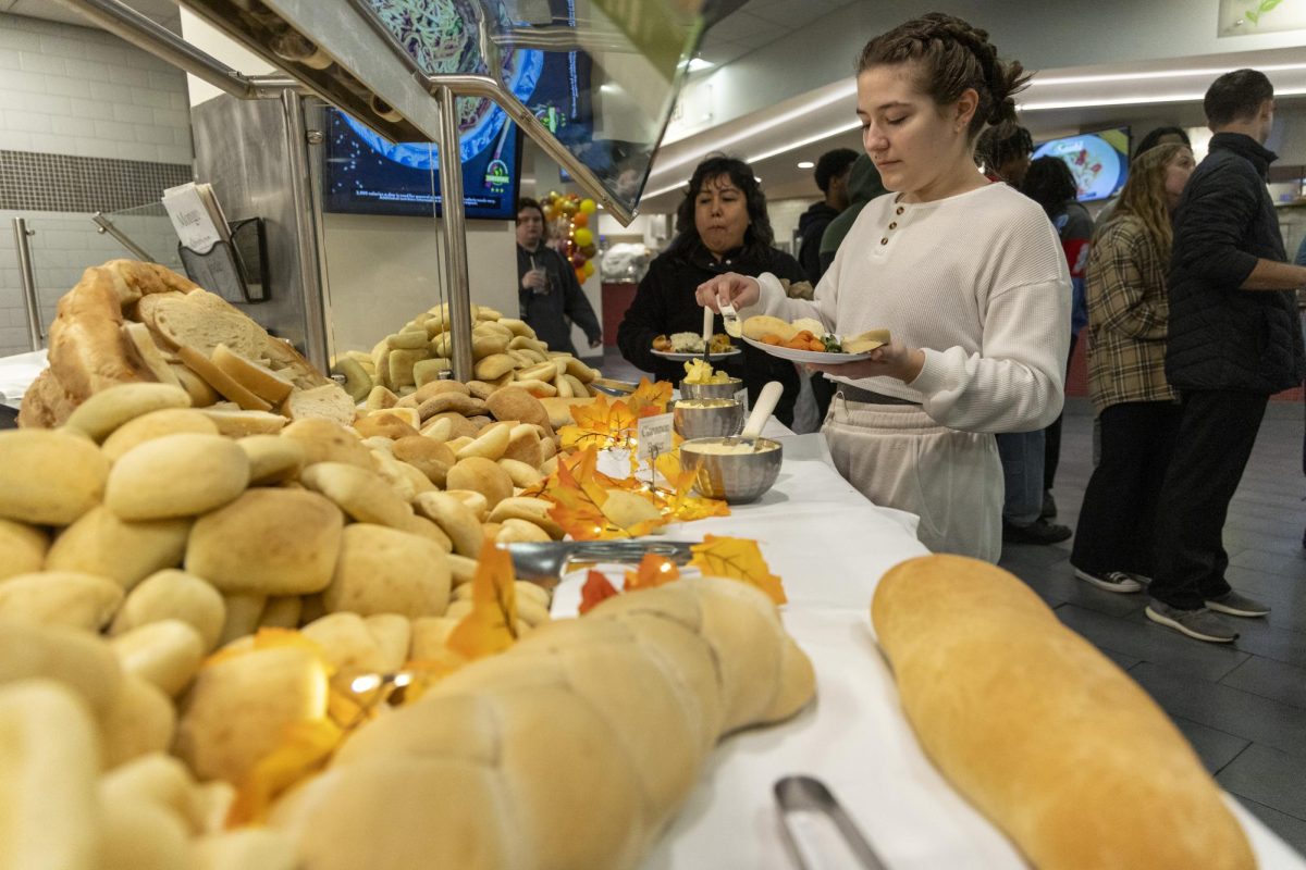 Renee Reinhardt scoops butter onto her plate during the annual Freshgiving event on Thursday, Nov. 21, 2023. 