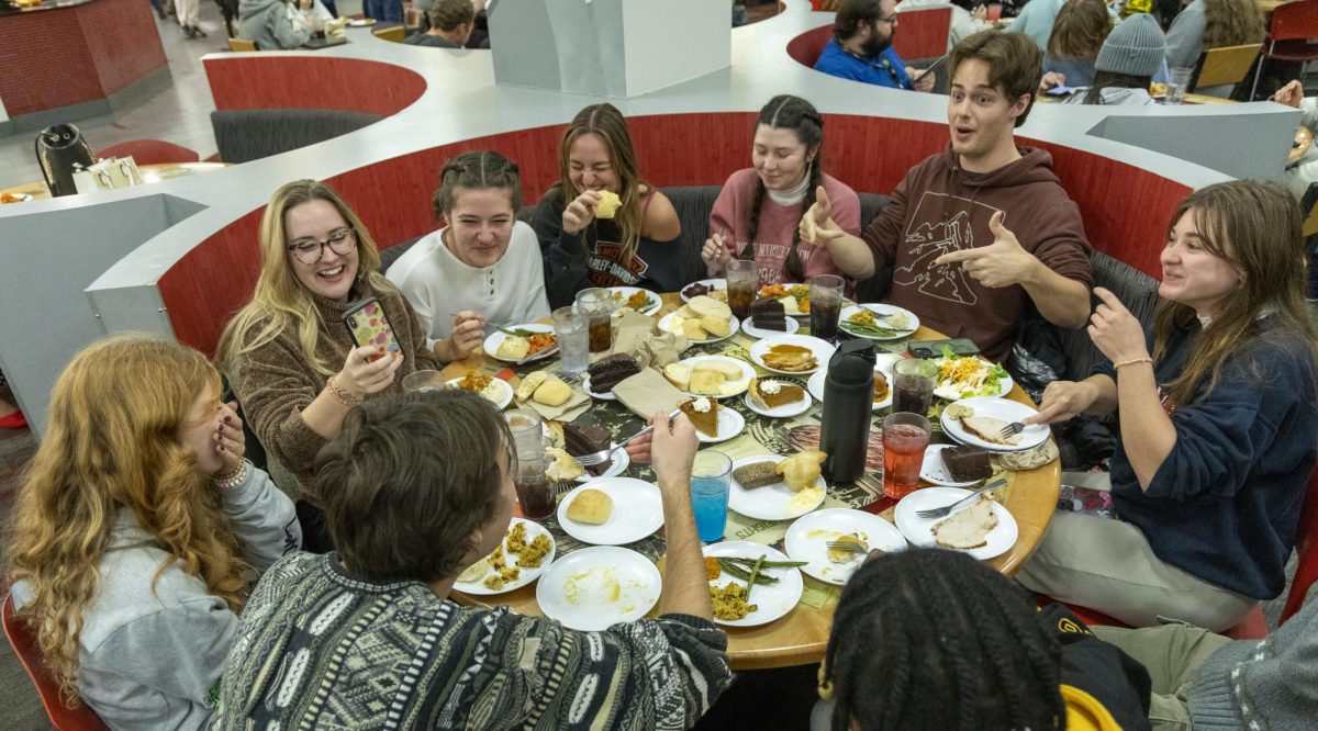 A group of friends laughs as they eat during the annual Freshgiving event on Thursday, Nov. 21, 2023. 