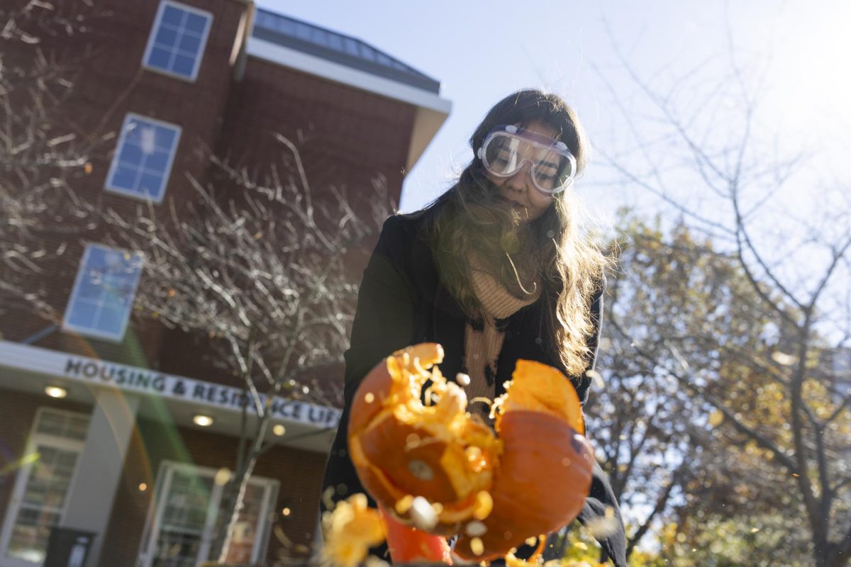 Foreign Exchange student Sarah Riahi smashes a pumpkin during Hope on the Hill in the DSU courtyard on Tuesday, Nov. 12, 2024. 