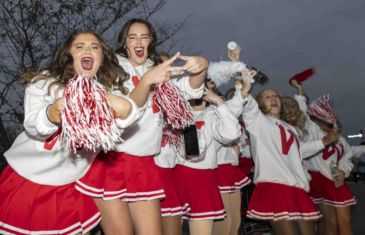 Alpha Delta Pi members Hannah Pickering (left) and Karlee Powell show their sorority signs before the homecoming parade on Friday, Nov. 15, 2024.