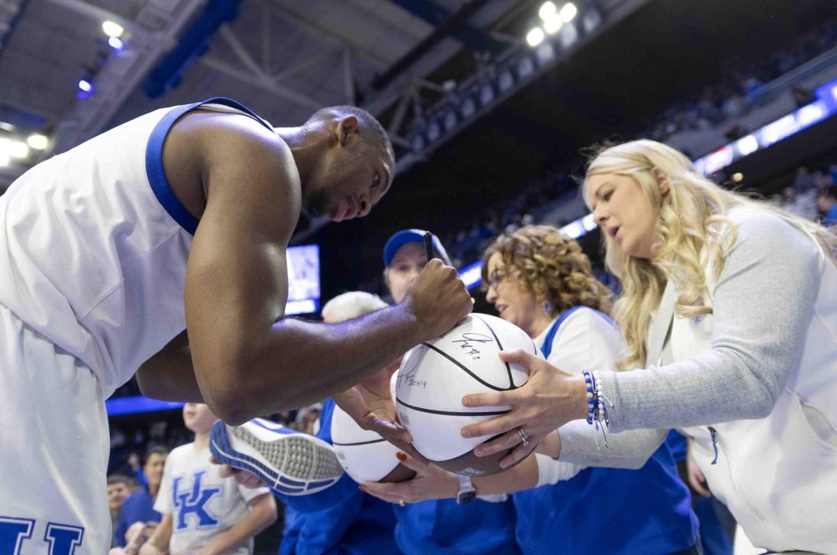 UK guard Lamont Butler signs a fan’s basketball after the basketball game against Western Kentucky University in Rupp Arena in Lexington, Ky., on Tuesday, Nov. 26, 2024. 