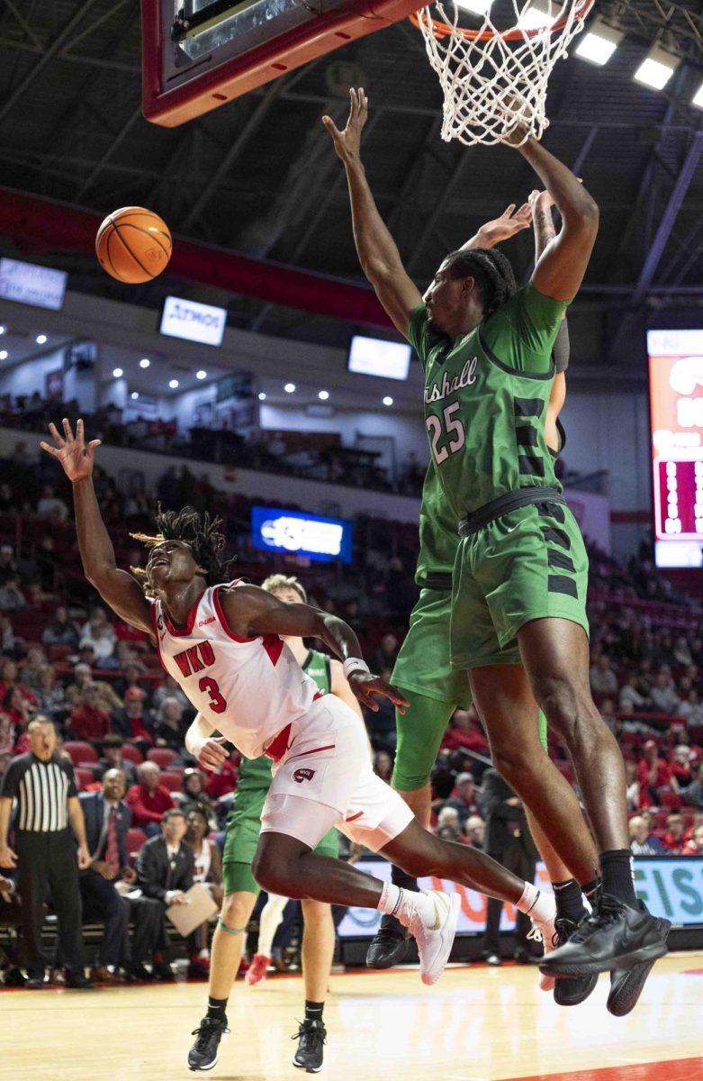 WKU guard Jalen Jackson (3) falls to the floor after being fouled by Marshall forward Obinna Anochili-Killen (25) in the second half of the game in E.A. Diddle Arena on Saturday, Nov. 30, 2024. 