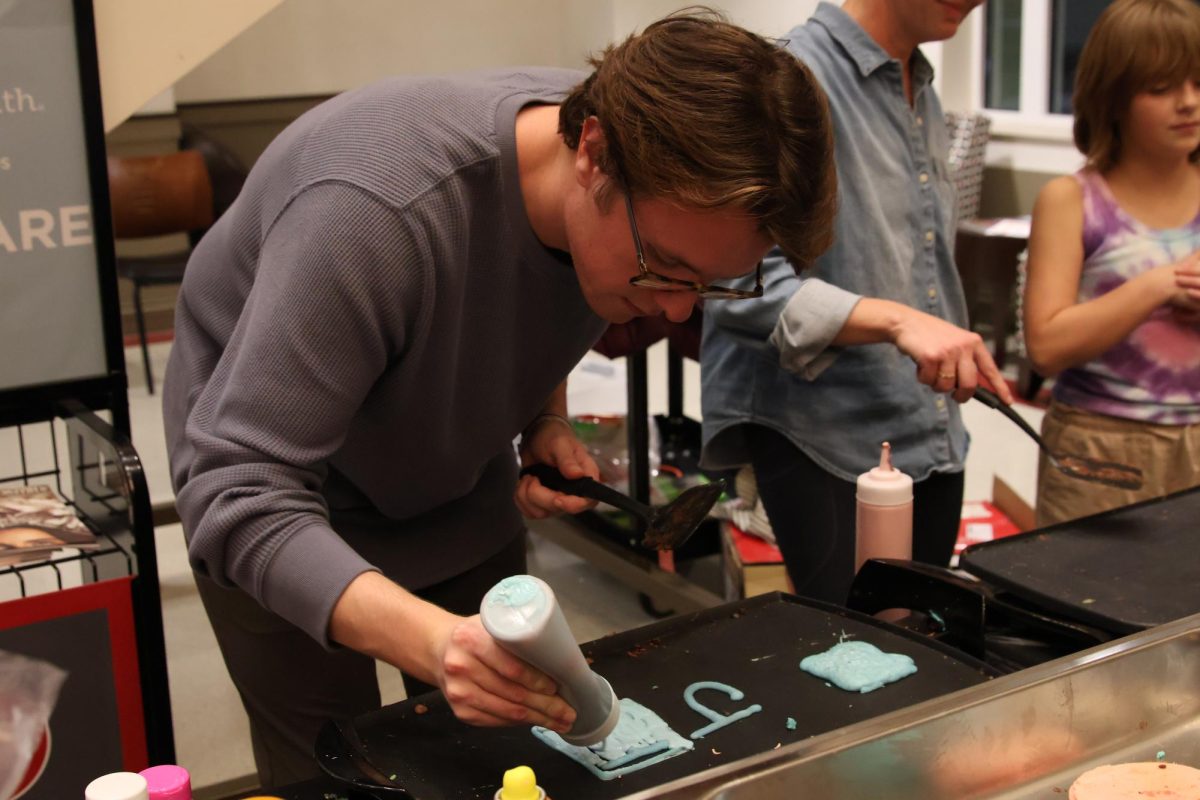 Jackson Hite makes pancakes with personalized designs for the Honors Students at the annual Mahurin Honors College Pancake Night on Nov. 20, 2024. 