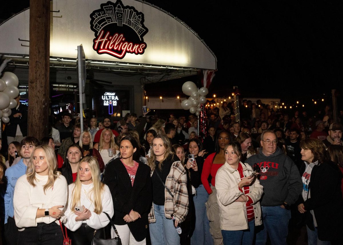 Parade spectators watch from outside of the Hilligans Restaurant off of College St. during the WKU Homecoming Parade in Bowling Green on Friday, Nov. 15, 2024. 