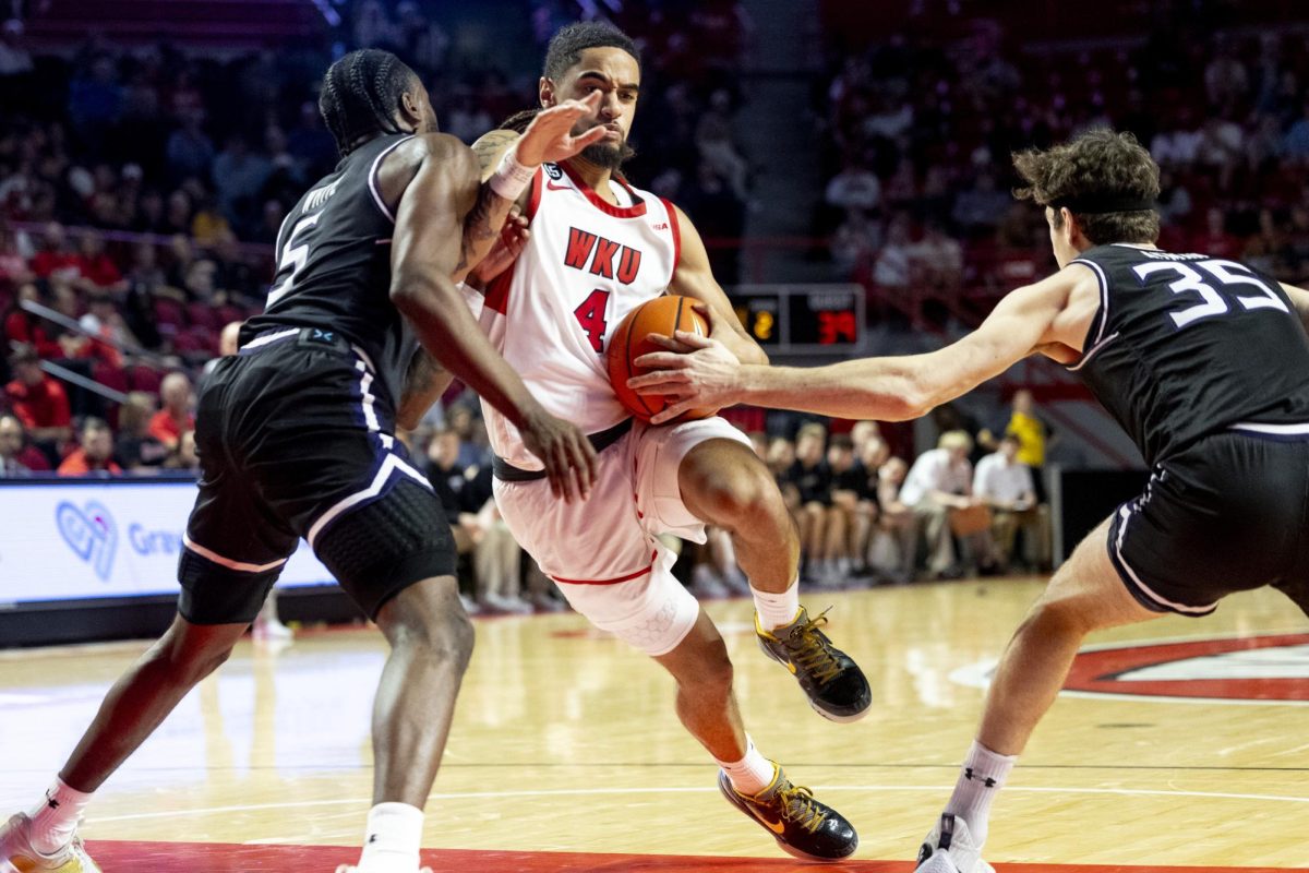 WKU guard Khristian Lander (4) is fouled by Lipscomb’s Miles White (5) on a run to the basket during WKU’s win against Lipscomb on Sunday, Nov. 17, 2024 in E.A. Diddle Arena. 