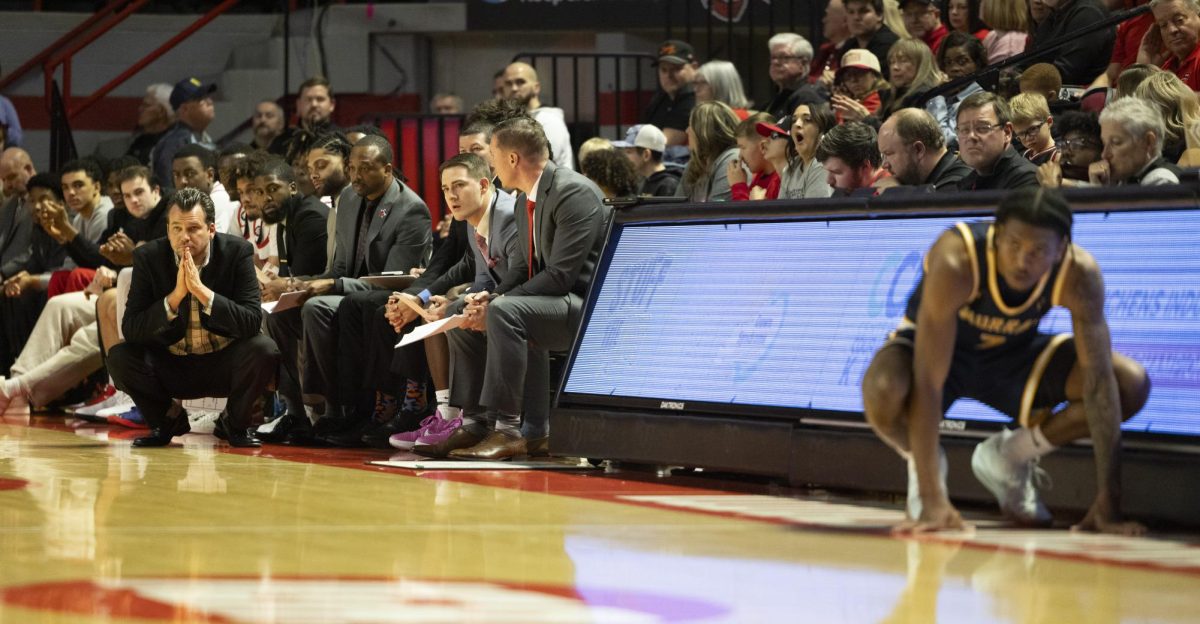 WKU head coach Hank Plona squats while watching his team on defense during the Hilltopper's game against the Murray State Racers in Bowling Green, Ky. on Saturday, Dec. 14, 2024.