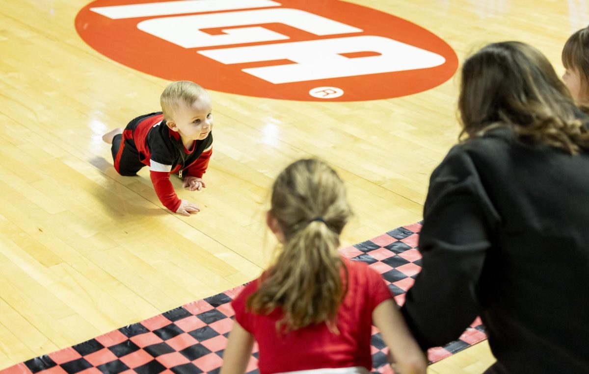 Knox Calvert, 1, crawls to his mother, Paige Calvert, and siblings and wins the race during the Hilltopper's game against the Murray State Racers in Bowling Green, Ky. on Saturday, Dec. 14, 2024.