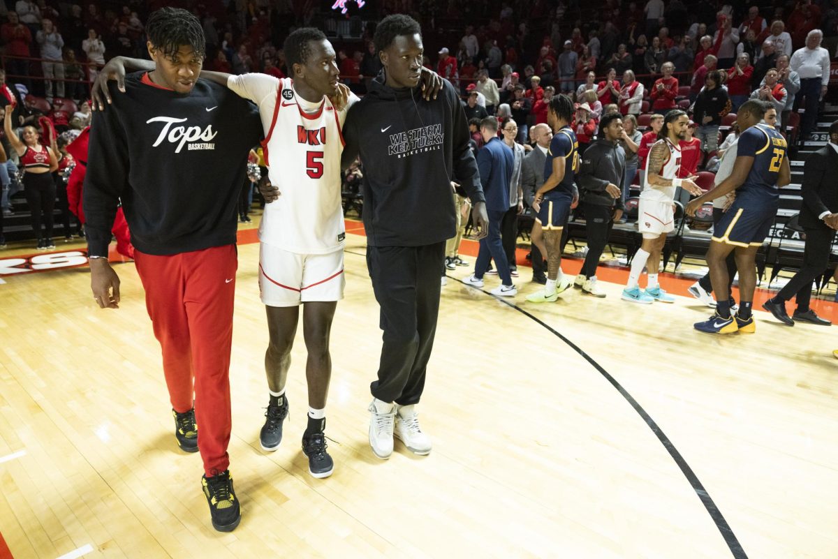 WKU forward Babacar Faye (5) walks to the locker room with the help of his teammates after the Hilltopper's game against the Murray State Racers in Bowling Green, Ky. on Saturday, Dec. 14, 2024.