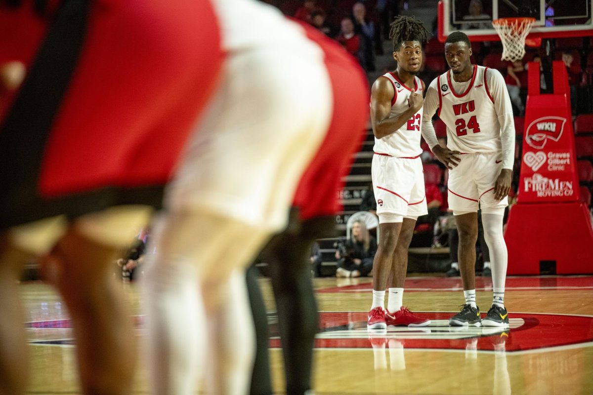 WKU guard Enoch Kalambay and forward Tyrone Marshall Jr. talk while their teammate makes a free throw during the Hilltopper's game against the Seattle Redhawks in Bowling Green, Ky. on Tuesday, Dec. 17, 2024.