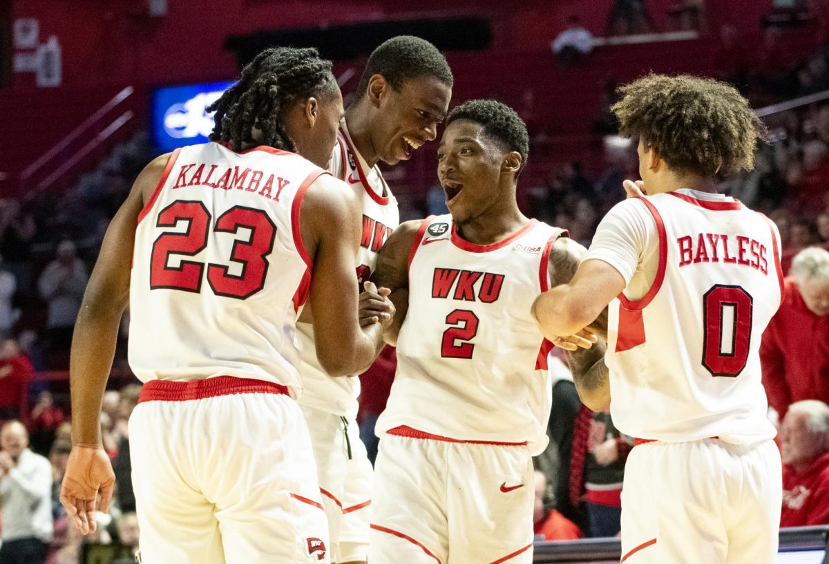 WKU guard Don McHenry (2) is helped to his feet while celebrating his three point field goal with his teammates during the Hilltopper's game against the Kentucky Wesleyan Panthers in Bowling Green, Ky. on Saturday, Dec. 21, 2024.