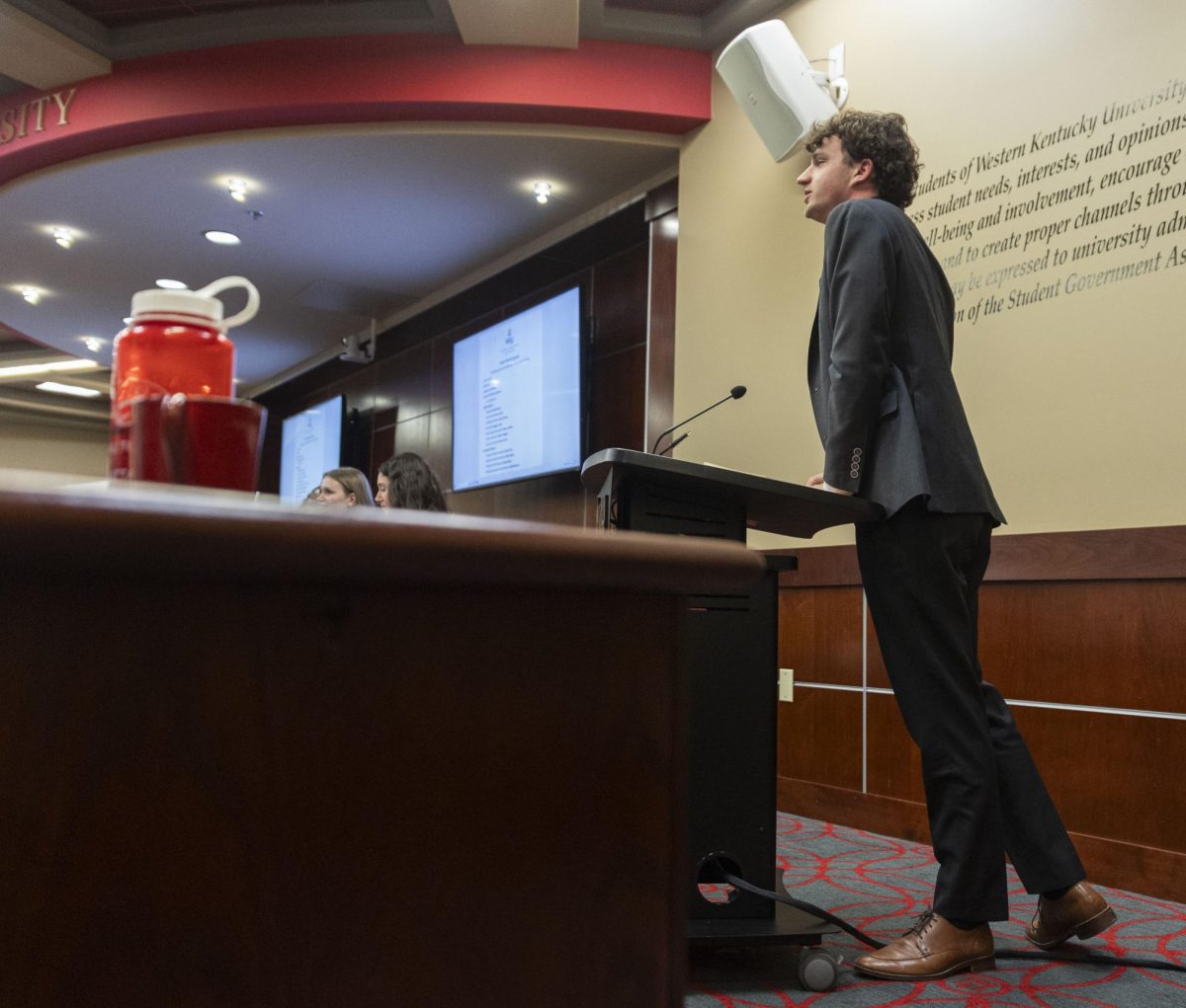 SGA President Rush Robinson leans on the podium as he gives his report during the SGA meeting on Tuesday, Aug. 26, 2025, in the Senate Chambers of the Downing Student Union building at Western Kentucky University.