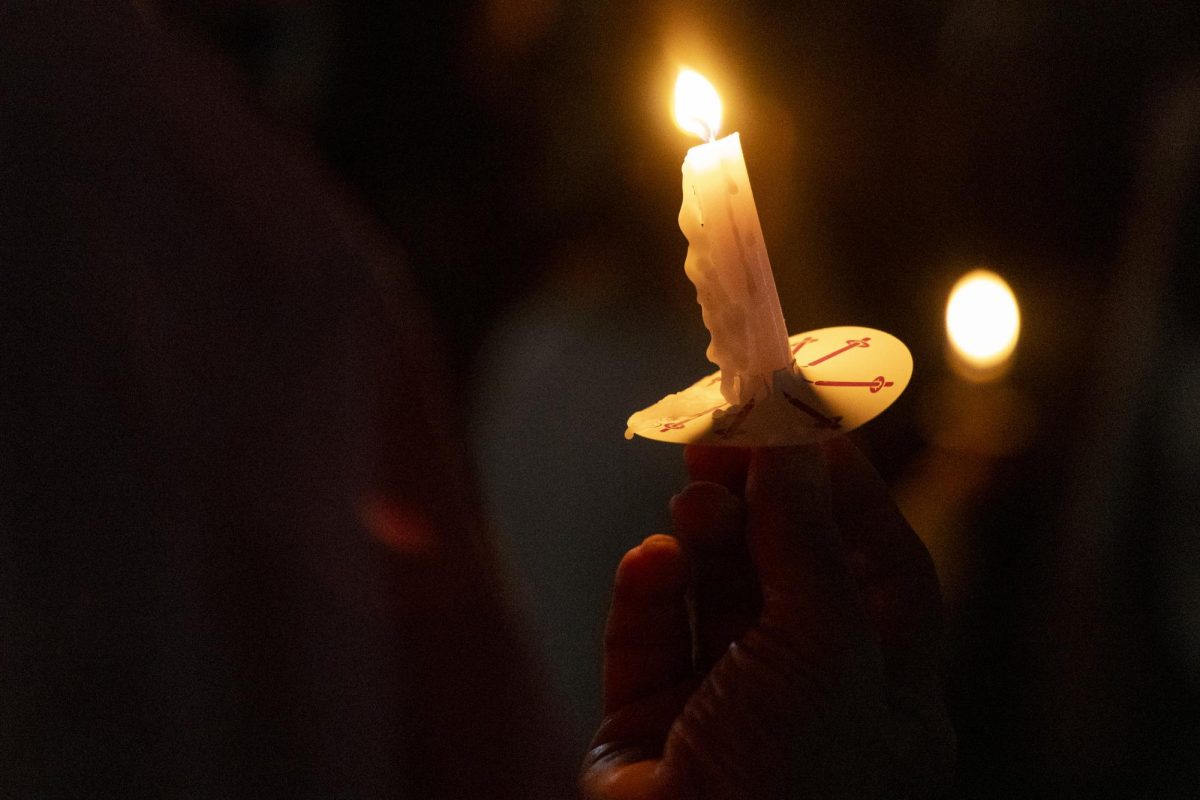 A supporter holds a candle during the WKU chapter of Turning Point USA’s vigil for conservative commentator Charlie Kirk on the South Lawn on Thursday, Sept. 25, 2025.