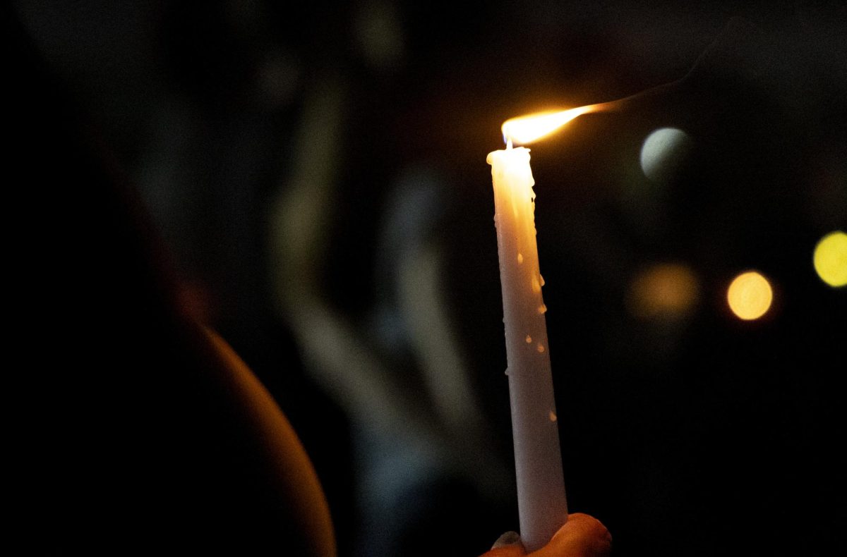 A supporter holds a candle during the WKU chapter of Turning Point USA’s vigil for conservative commentator Charlie Kirk on the South Lawn on Thursday, Sept. 25, 2025.