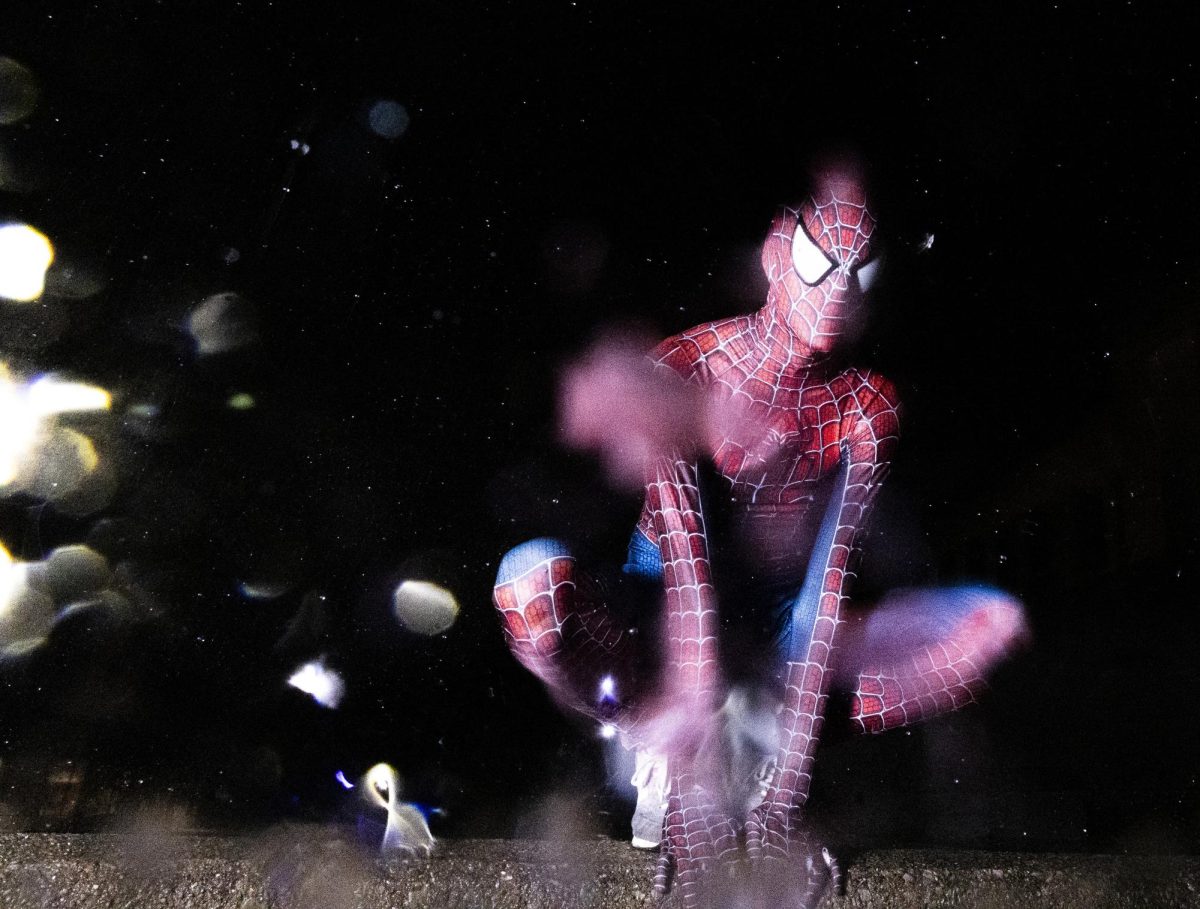 The WKU Spiderman poses for a portrait outside the Commons in the rain on Tuesday, Sept. 26, 2025. "I've been doing this for three years. I originally did this to build up the spirits of kids in financially unstable or violent homes and to just bring hope to the communities. I'm here to do it with WKU to tell a story, as well as with these other guys, through my passion for writing and film," he said.