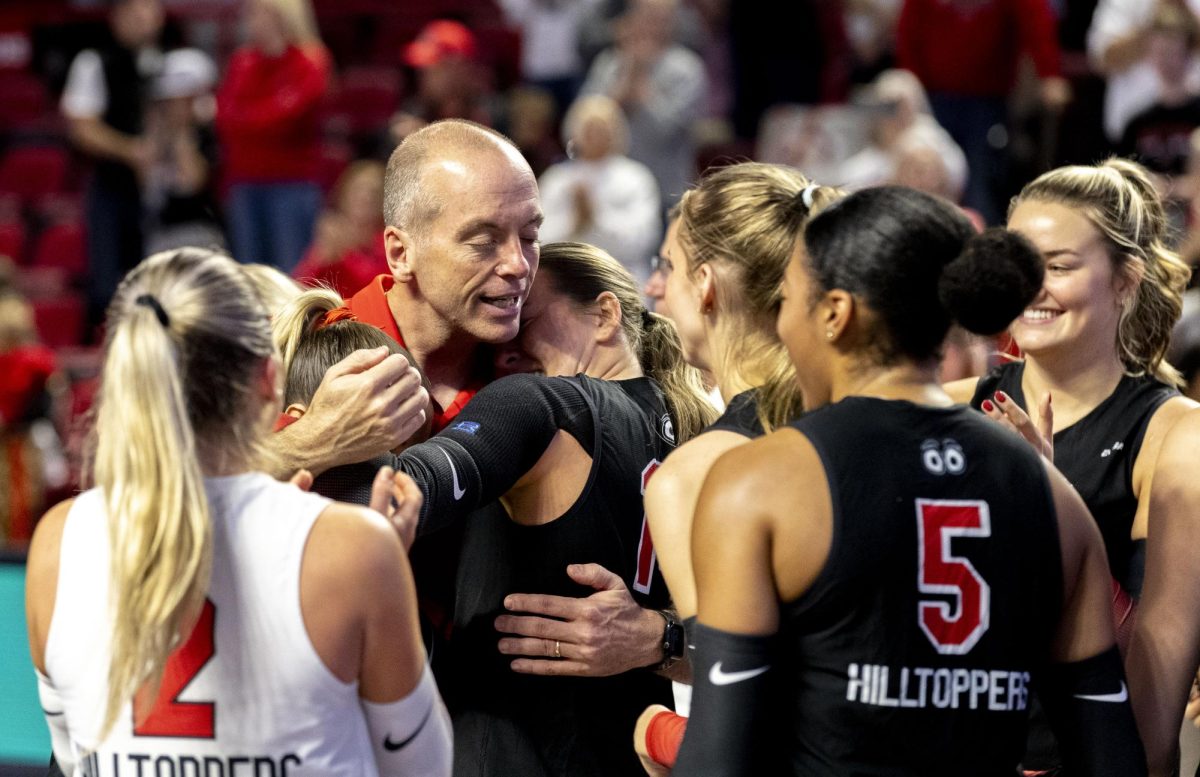 Western Kentucky University head coach Travis Hudson celebrates with a group hug from the team after WKU’s game against Delaware in E.A. Diddle Arena on Saturday, Nov. 8, 2025. 