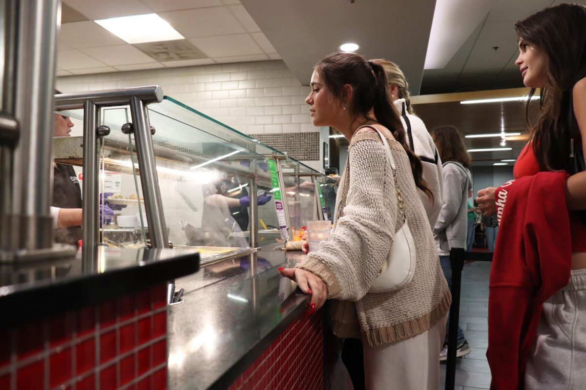 Sophie Burns, a freshman from Nashville and business major, waits for her plate from the food service workers at Fresh Foods Company for her first Friendsgiving on Thursday Nov. 20, 2025.