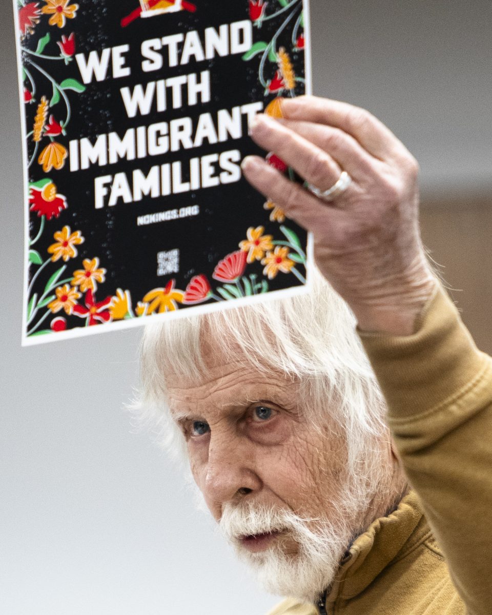 Michael Gramling, a member of the leadership team for SOKY Indivisible, holds up posters meant to be displayed in local businesses around Bowling Green during an interest meeting held by the Bowling Green Community Defense at Lisa Rice Library on Saturday, Jan. 31, 2026.