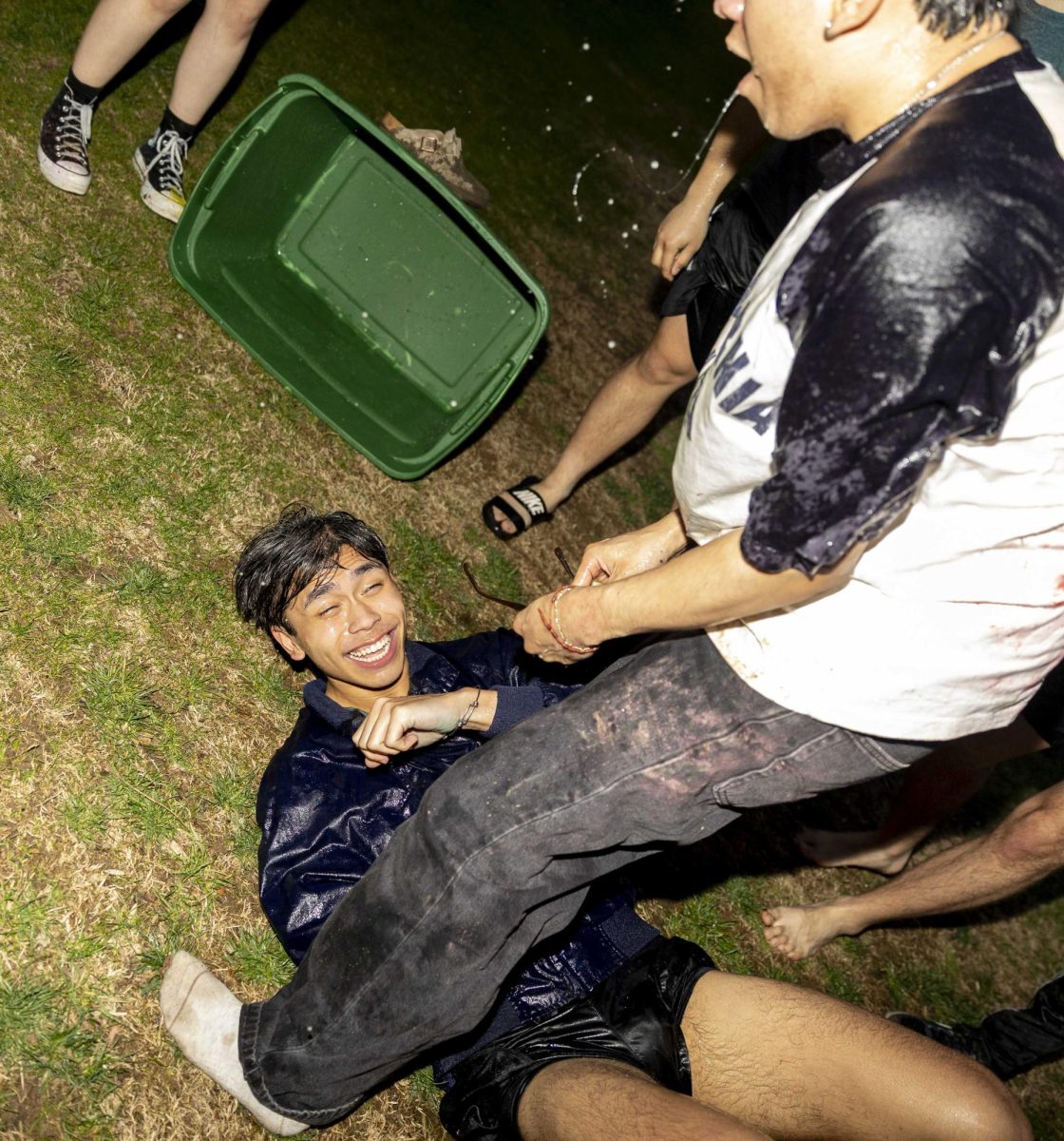Junior Jose Velez stands over junior nursing major Jason Le after being doused by excess water from the tub of water balloons during the WKU Asian American Association’s Holi Celebration at South Lawn on Thursday, March 5, 2026. 