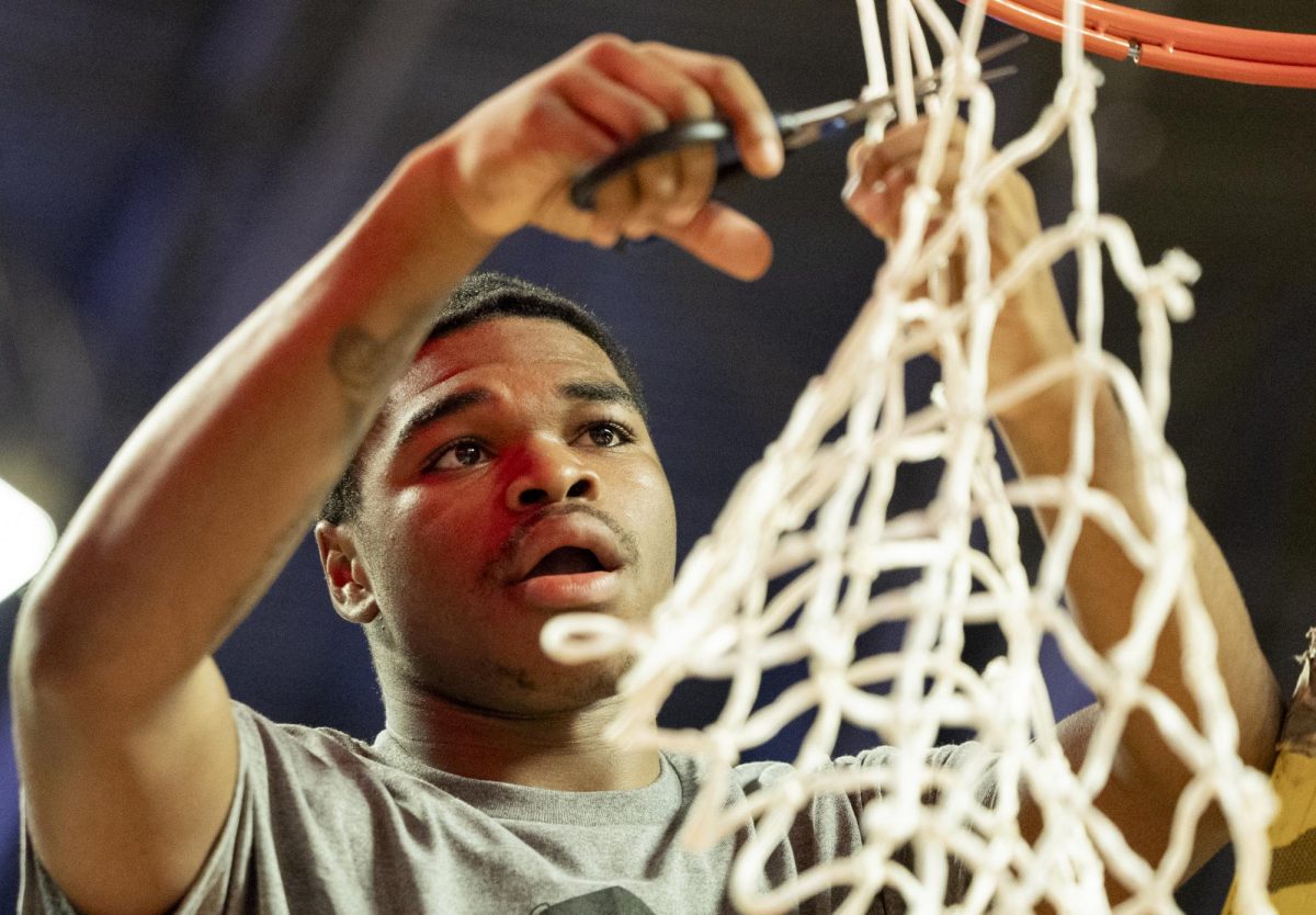 Warren Central High School junior shooting guard Damarice Smith (30) cuts off a piece of the goal net after his team wins the KHSAA Fourth Region boys basketball championship game against South Warren High School at E.A. Diddle Arena on Tuesday, March 10, 2026. 