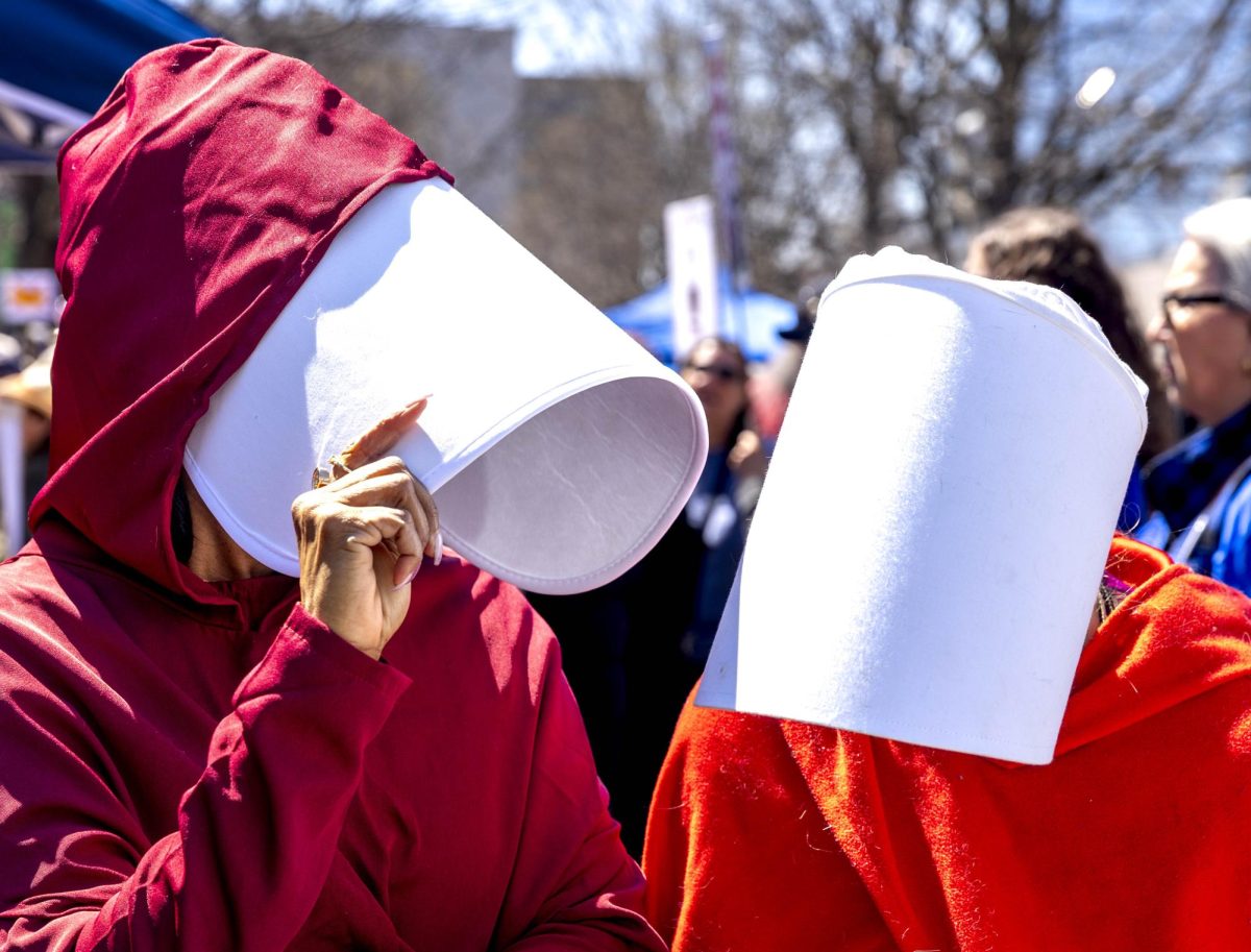 Carla Perry (izquierda) y Victoria Vigil (derecha) se ríen juntas al darse cuenta de que ambas van vestidas de criadas tras conocerse por primera vez en la manifestación “No Kings” celebrada frente al juzgado de distrito Robert F. Stephens en Lexington, Kentucky, el sábado 28 de marzo de 2026.