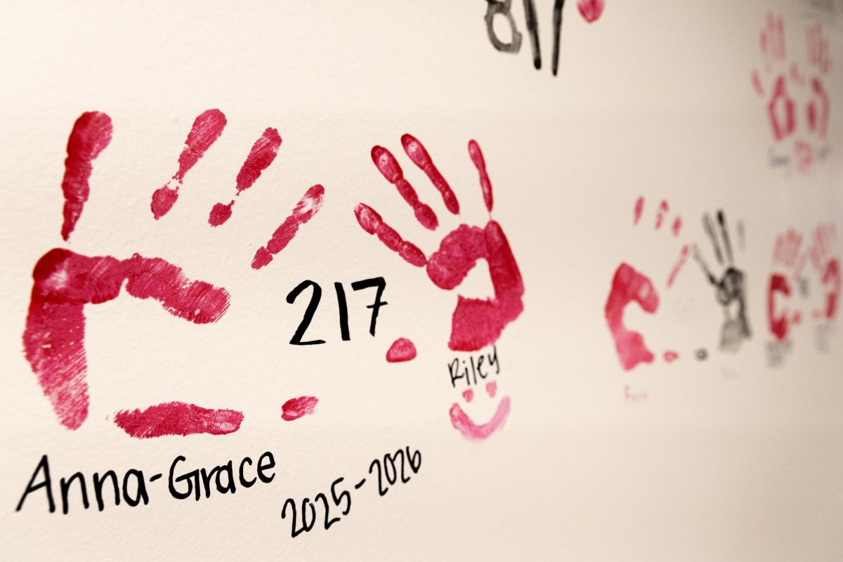 Residents and alumni of Hugh Poland Hall place their handprints and written messages by the entrance at Western Kentucky University, Thursday, April 30, 2026.