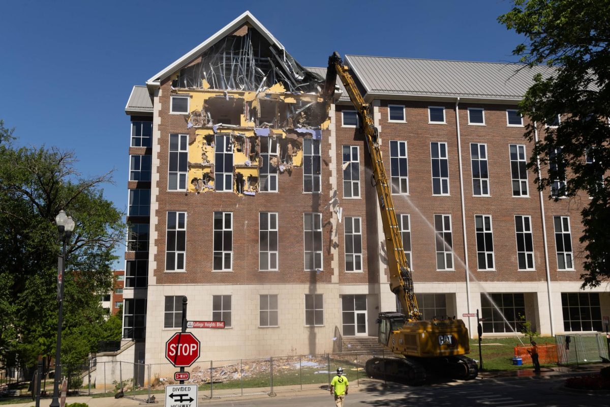Construction workers spray the building with a water hose to prevent excess dust from getting in to the air on Tuesday, May 12, 2026. 