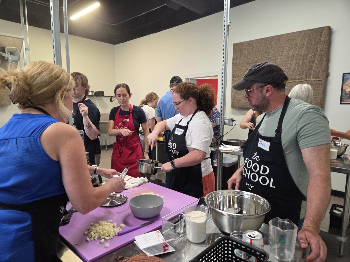 Members of the purple team ask Ana Kulka to look at their bean and cheese filling before starting to assemble their pupusas. Photo taken June 13, 2026 at The Food School.