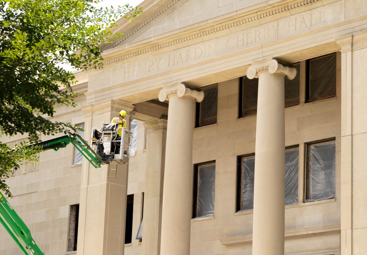 A construction worker is lowered to the ground after working on renovating the front exterior of Henry Hardin Cherry Hall on July 7, 2026. 